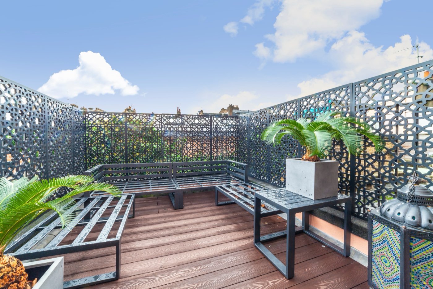Decked roof terrace with decorative screens and planting at Standen Road, by LINX