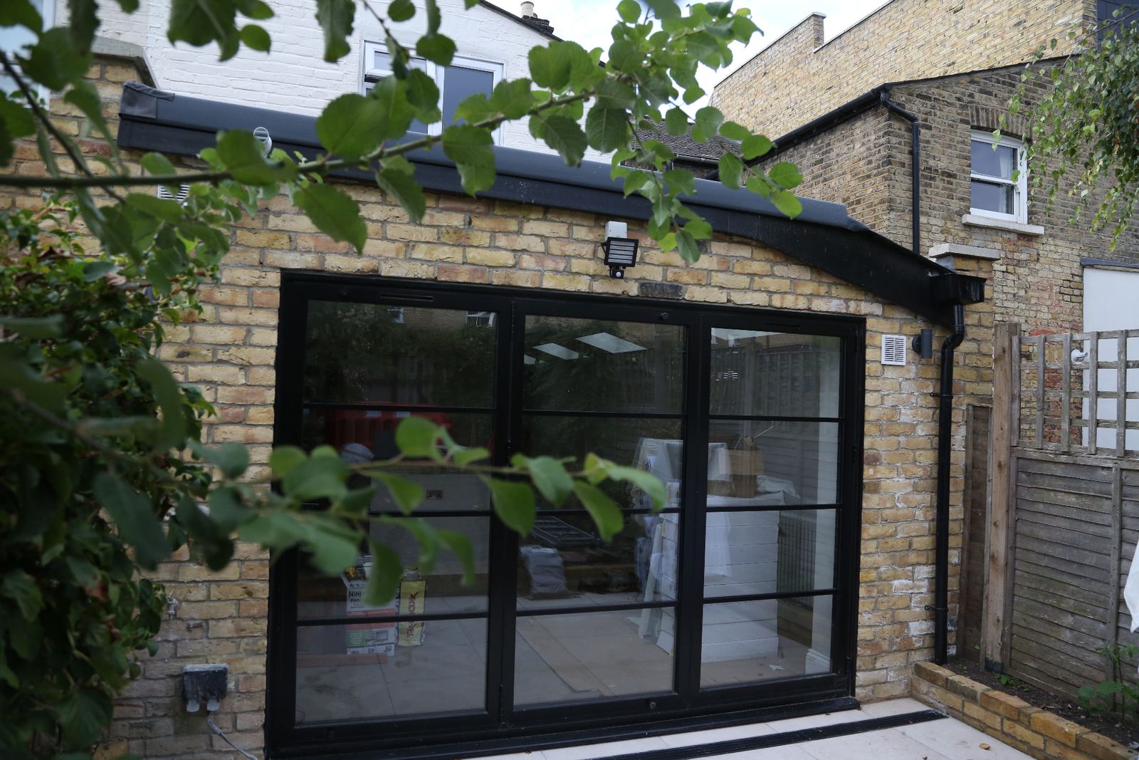 Completed LINX rear extension with black steel-framed glazing onto the garden